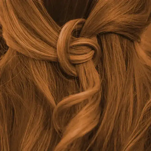 Langes, warm nougatbraunes Haar mit elegantem Knoten, Detailaufnahme Frisur