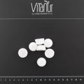 Bio Zahnkristalle Xylit Zitrone, weiße Tabletten von VitaNur auf schwarzem Hintergrund mit Maßstab