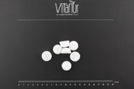 Bio Zahnkristalle Xylit Zitrone, weiße Tabletten von VitaNur auf schwarzem Hintergrund mit Maßstab