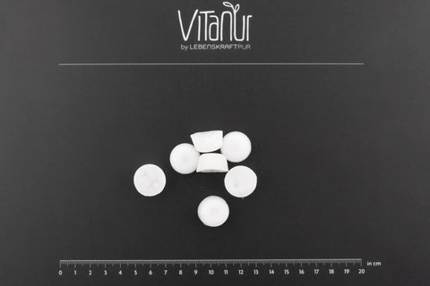 Bio Zahnkristalle Xylit Zitrone, weiße Tabletten von VitaNur auf schwarzem Hintergrund mit Maßstab