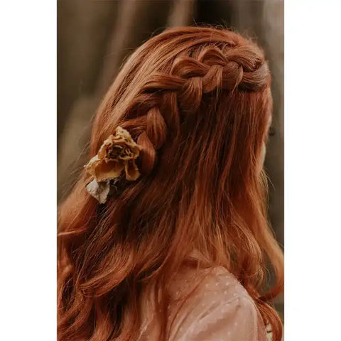 Geflochtene rote Haare mit Trockenblume, Boho Frisur, Outdoor-Hintergrund